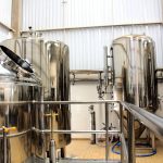 A view of stainless steel tanks in a modern brewery, showcasing industrial machinery and production equipment.