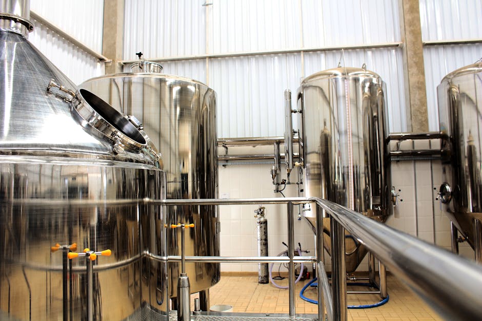 A view of stainless steel tanks in a modern brewery, showcasing industrial machinery and production equipment.
